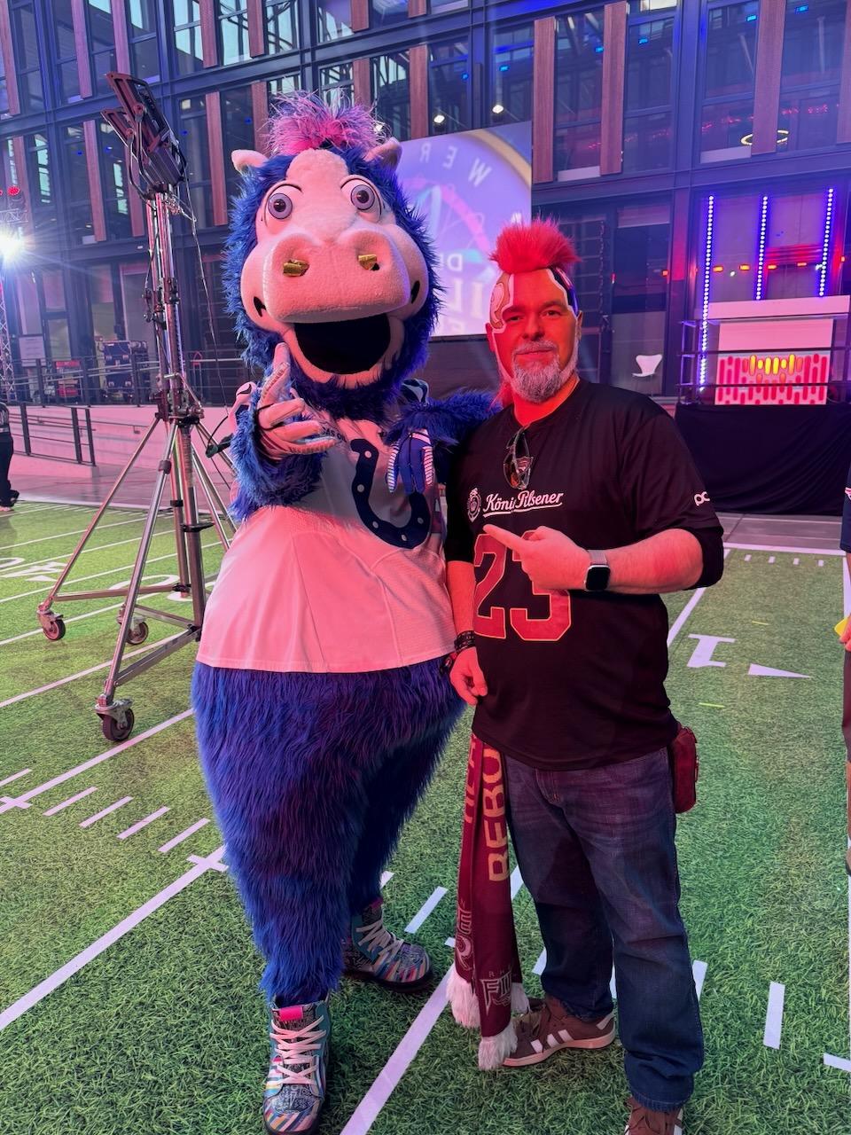 Colts-Maskottchen Blue posiert mit einem Footballfan auf der Footballfläche